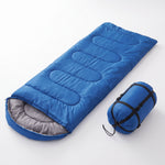 Saco de dormir azul extendido junto a su bolsa de transporte
