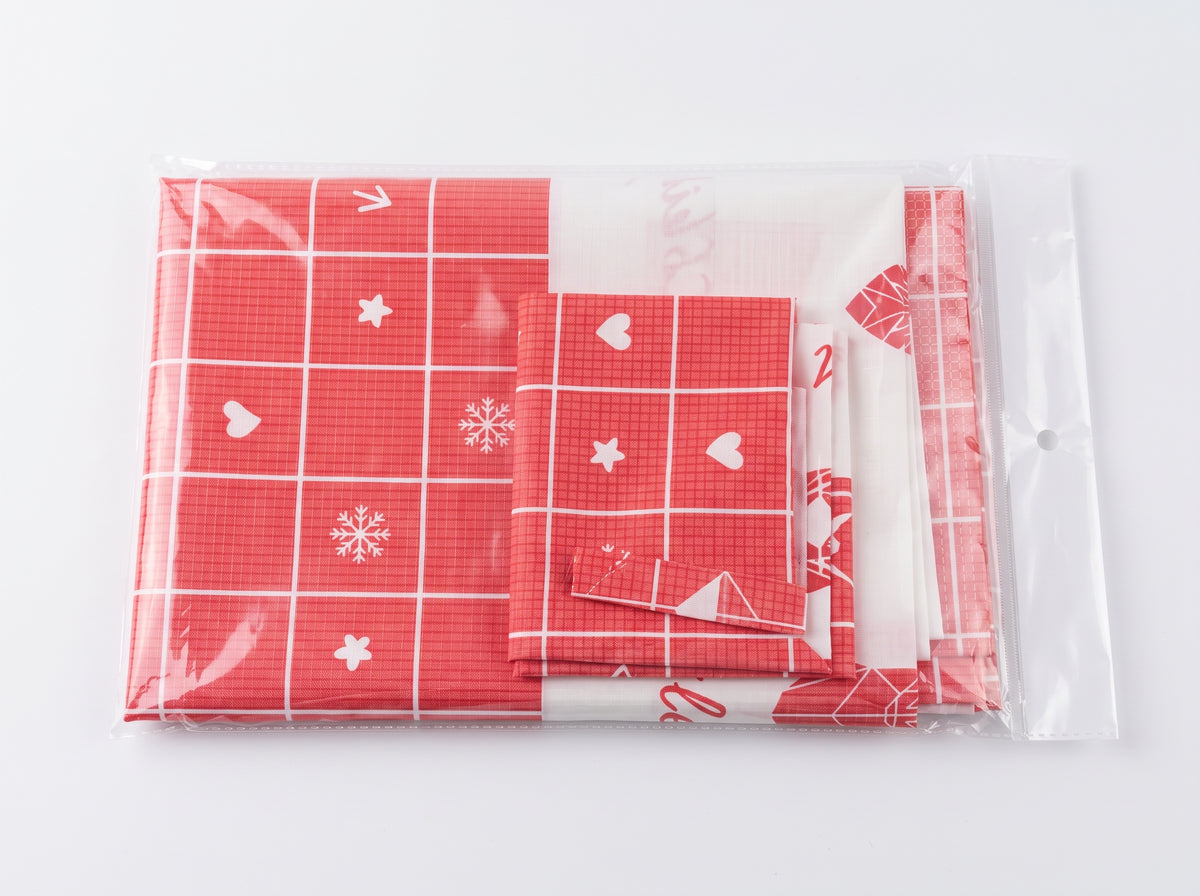 Mantel navideño rojo doblado junto a su empaque